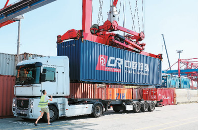 图为在德国汉堡,塔吊将一个中欧班列集装箱放置在一辆卡车上。 新华社记者 单宇琦摄